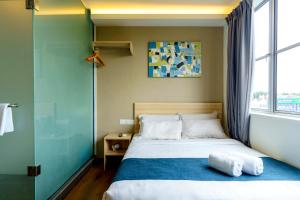 a bedroom with a bed with a glass door and a window at Orange Hotel Kota Kemuning @ Shah Alam in Shah Alam +31 photos