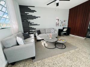 ein Wohnzimmer mit einer Couch und einem Tisch in der Unterkunft Savvys Place in Ponce