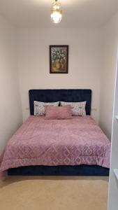 a bedroom with a bed with a purple comforter at L'ombre appart in Tangier
