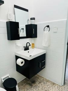 ein Badezimmer mit Waschbecken und Spiegel in der Unterkunft Savvys Place in Ponce