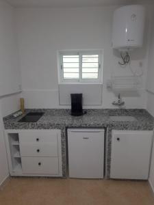 a kitchen with white cabinets and a counter top at L'ombre appart in Tangier +11 photos