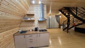 a kitchen with a stove and a staircase in a room at Wood cottage in Borjomi in Borjomi