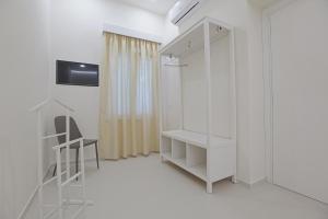 Camera bianca con armadio e sedia di Casa Ancora Fronte Mare a San Leone