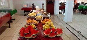 a table filled with different types of fruit on plates at Hotel Glória in São Gabriel