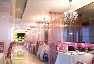 a restaurant with white tables and chairs and a chandelier at Yes Motel in Zhonghe