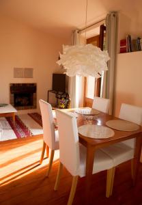 a dining room table with white chairs and a chandelier at Apartamento La Costa in Peralada