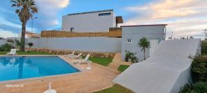 a house with a swimming pool and a building at Casa Papillon in Sagres