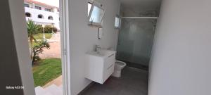 a bathroom with a toilet and a sink and a window at Casa Papillon in Sagres +23 photos