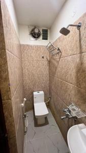 un baño con inodoro y lavabo en Hotel Subha Residency Bangalore, en Bangalore 79 fotos más