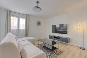 トルシーにあるDisney apartment for 6 peopleの白いソファとテレビのあるリビングルーム