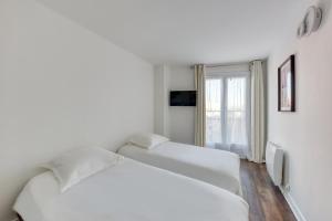 トルシーにあるDisney apartment for 6 peopleの窓のある白い部屋にベッドが2つある
