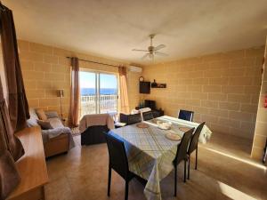 a living room with a table and a couch at Palm Court Apartment in Xlendi