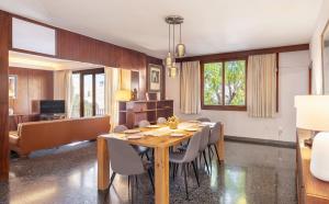 Un comedor con una gran mesa y sillas de madera. en Villa Palma 2, en Palma de Mallorca