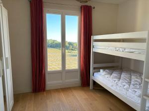 a bedroom with two bunk beds and a window at Mas de l'Archange in Montagnac