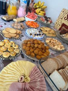 a table with many different types of food on it at Casa Pérolas do Mar in Balneário Camboriú