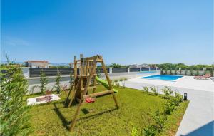 a wooden swing in a yard next to a pool at Villa Katarina Privlaka in Privlaka