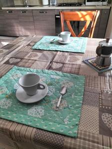 a table with two cups and a plate and spoon at La casa di Beba in Collescipoli