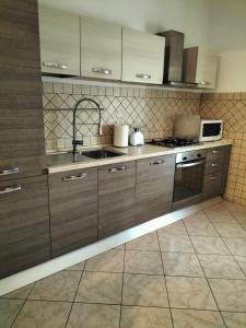 a kitchen with wooden cabinets and a sink at La casa di Beba in Collescipoli