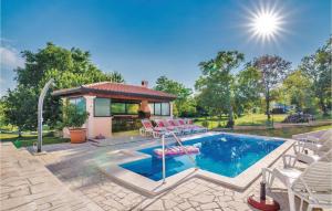 una piscina con sedie e una casa di Holiday Home Vinez V a Vinež