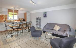 a living room with a couch and a table and chairs at 3 Bedroom Nice Home In Saint-Thomé in Saint-Thomé