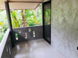 ein Raum mit einer Tür und einem Baum im Hintergrund in der Unterkunft Midigama Home Stay Villa Apartment in Weligama