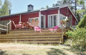 a house with pink chairs and a table on a deck at Cozy Home In Djurhamn With Wifi in Djurhamn