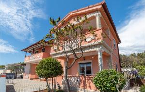 a pink house with trees in front of it at Apartment Betiga With Sea View 02 in Barbariga