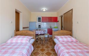 two beds in a room with a kitchen and a table at Apartment Betiga With Sea View 02 in Barbariga +9 photos