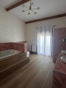 a large bathroom with a tub and a large window at Casa Rural Mateo Corchero in Villanueva de la Sierra