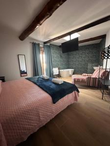 a bedroom with a large bed and a bathroom at Casa Rural Mateo Corchero in Villanueva de la Sierra +12 photos