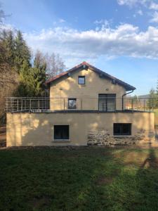 a house with a balcony on top of it at La Ruine Single-family House with Hot Tub in Laveline