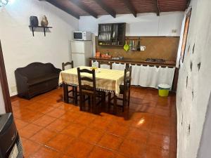 a kitchen with a table with chairs and a refrigerator at Casa Rural Higuera Morales in Mocanal