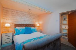 a bedroom with a large bed with blue pillows at Host & Stay - Pied-a-Terre at Manor View in Bury