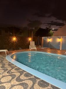 a swimming pool at night with a chair and a chair at Casa Pérolas do Mar in Balneário Camboriú