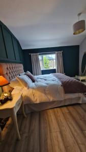 a bedroom with a bed and a desk and a window at Yellow Stone Farm Lodge and Spa in Clonbrown