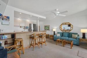 a living room with a blue couch and a kitchen at KIHEI SURFSIDE, #403 condo in Wailea