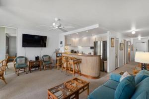 a living room with a blue couch and a kitchen at KIHEI SURFSIDE, #403 condo in Wailea