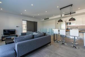 a living room with a couch and a television at Sage Villa by Vintage Travel in Tavronitis