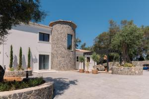 ein großes weißes Haus mit einer Steinsäule in der Unterkunft Zervos by Vintage Travel in Corfu