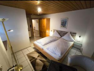a bedroom with a bed with white sheets and pillows at Pension im Charme der 90er in Trier