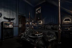 杜塞尔多夫Hotel Villa Achenbach的黑暗的客房配有床、椅子和桌子