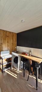 a room with a table and a black wall at Tiny estrella sur y tinaja in Pitrufquén