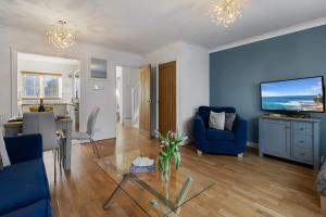 a living room with blue walls and a dining room at Quay Retreat - Short Stays UK Ltd in Exeter