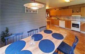 a dining room table with blue chairs and a kitchen at Gorgeous Home In Reksteren With Kitchen in Hope