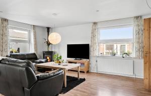 a living room with a couch and a tv at 4 Bedroom Beautiful Home In Holstebro in Holstebro