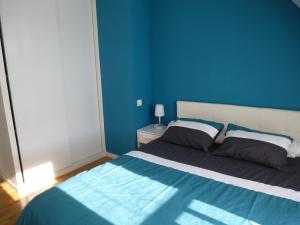 サルゾーにあるMaison Sarzeau-St Jacques - 100 m de la merの青い壁のベッド付きの青いベッドルーム1室