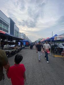 a group of people walking through an outdoor market at Jom singgah in Seri Iskandar