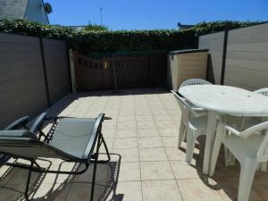 サルゾーにあるMaison Sarzeau-St Jacques - 100 m de la merのパティオ(白いテーブル、椅子付)