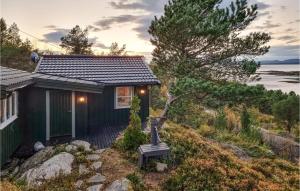 a small house with a bench in front of it at Cozy Home In Kjørsvikbugen With Wifi in Taftøya