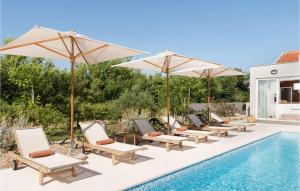プリヴラカにあるVilla White Goldのスイミングプールの隣の椅子とパラソルのグループ +30枚の写真